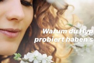 Frau schaut eine BLume an