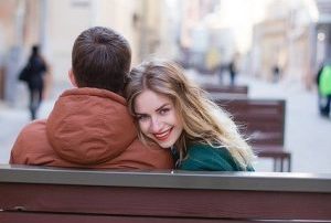 Frau lächelt über Schulter eines Mannes